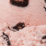 Pink ice cream with chocolate chunks.