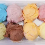 Eight colorful ice cream scoops in container.