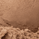 Brown textured surface with rough, uneven terrain.