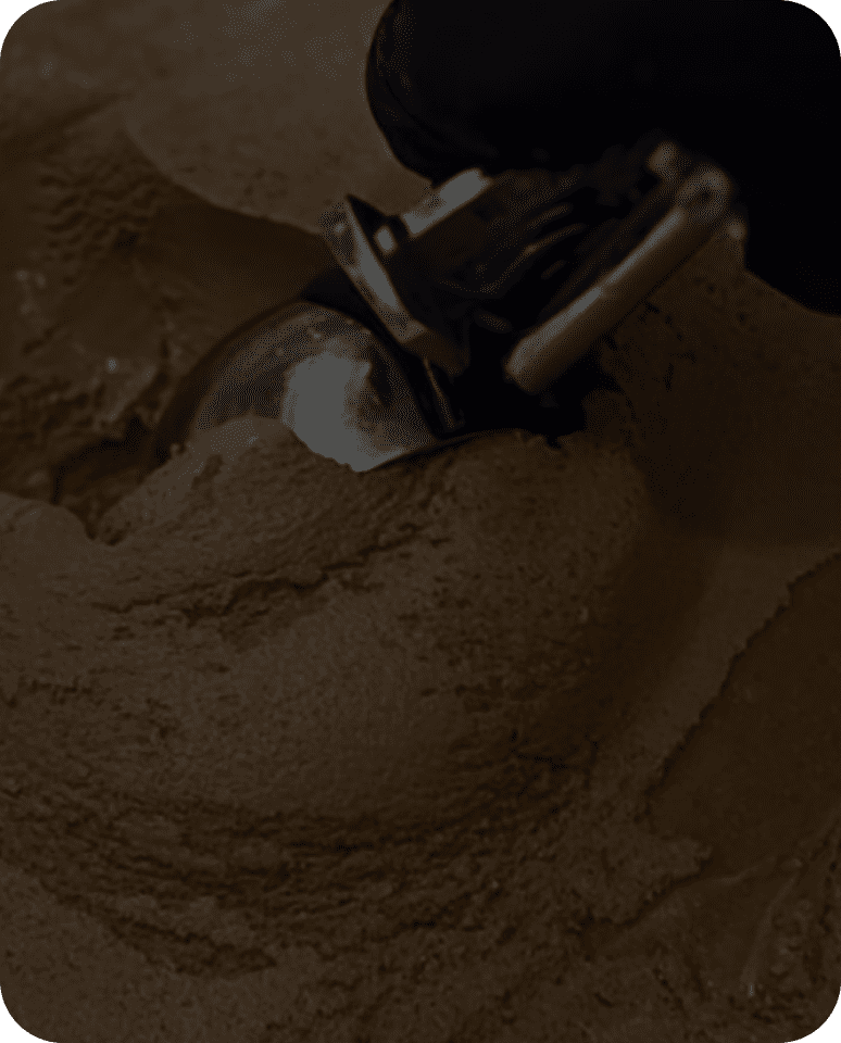 Scooping chocolate ice cream with metal scoop.