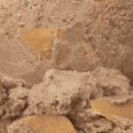 Brown ice cream with cookie pieces.