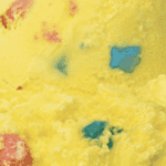 Yellow ice cream with colorful candy pieces.
